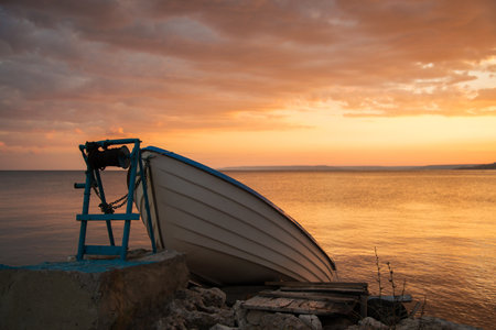 Sunset over the fishing pier and a lonely boat - selective focusの写真素材
