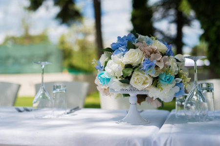 Table set with white and blue roses. Garden party concept. Selective focus.