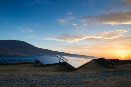 Solar panels, photovoltaics, alternative source of electricity - concept of sustainable and renewable sources. Low light morning down shot with natural sun reflection and dew drops. Selective focus.の写真素材