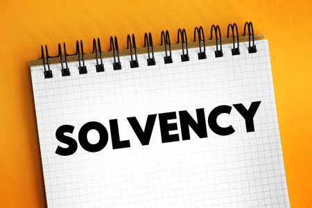 Solvency - the possession of assets in excess of liabilities, ability to pay one's debts, text concept on notepadの写真素材