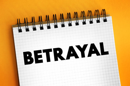 Betrayal - the action of betraying one's country or a person, treachery, text concept on notepadの写真素材