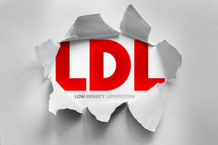 LDL abbreviation for "Low-Density Lipoprotein" revealed behind torn paper. Symbolic representation of cholesterol, heart health risk, medical diagnosis, cardiovascular disease, and healthcareの写真素材