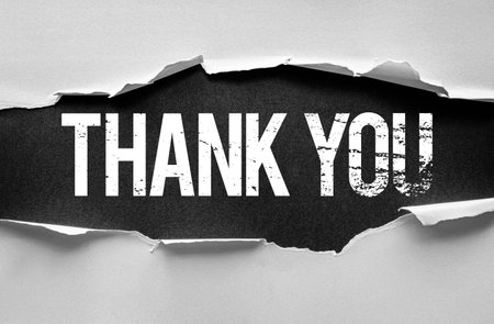 THANK YOU text emerges beneath torn paper with a weathered font style, symbolizing gratitude, appreciation, and recognition in a creative and visually striking presentationの写真素材