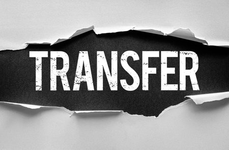 TRANSFER word revealed under torn paper with rough, grunge texture. Symbolic concept for relocation, data exchange, money movement, job switch, or shifting responsibilities and rolesの写真素材