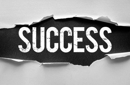 Word SUCCESS in bold textured typography revealed behind torn paper edges. Motivational concept symbolizing achievement, ambition, growth, opportunity, or breakthrough in career or lifeの写真素材