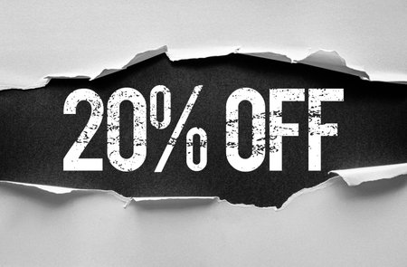 Bold distressed "20% OFF" text revealed through torn paper layers. Eye-catching discount banner or promotion graphic concept perfect for advertising, marketing, sales, or retail campaignsの写真素材