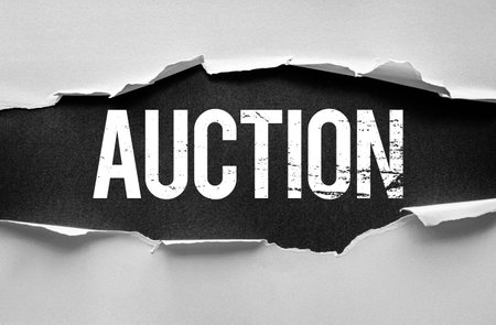 Bold distressed âAUCTIONâ text revealed through torn paper, symbolizing urgency and competitive bidding. Ideal for promotions, online sales, marketing, and business-themed visualsの写真素材