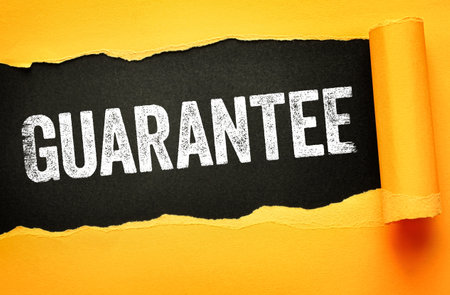 GUARANTEE written in bold, distressed white letters on a black background revealed through torn yellow paper. Eye-catching concept for assurance, warranty, promise, or risk-free offer messagingの写真素材