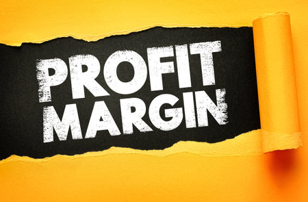 PROFIT MARGIN in bold white textured font revealed through a torn yellow paper background over black. Concept image for business profitability, financial analysis, and company performanceの写真素材