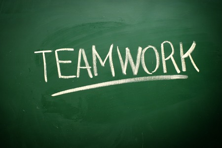 Handwritten Teamwork word with white chalk on a blackboardの写真素材