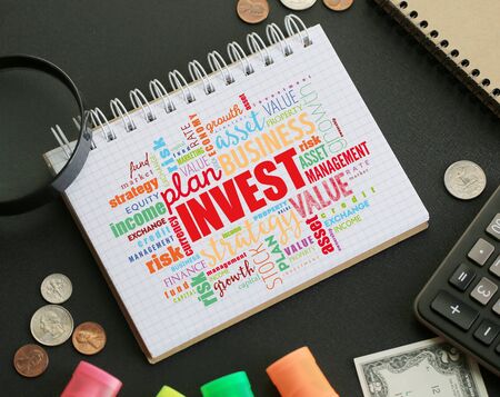 Invest word cloud in notebook on the desk, business concept backgroundの写真素材