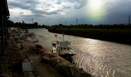 A fishing boat on the river at sunsetのeditorial素材