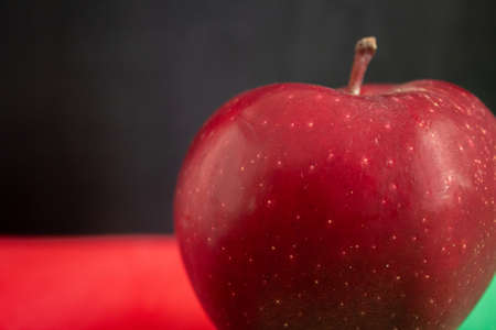 Single red apple photo. Zoom angle to natural organic apple with black background