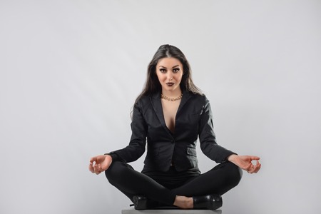 long hair brunette girl in jacket lotus poseの写真素材