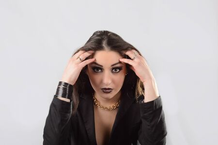 frustrated beautiful long hair brunette in a black jacket on a white background