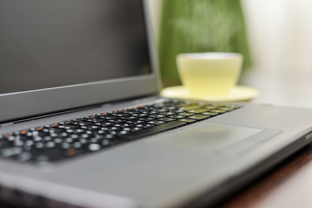 Laptop an address book and pen on the brown table.の写真素材