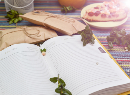 notepad, paper envelope and piece of pie on the colorful tablecloth. sunlightの写真素材