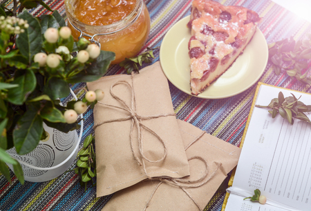 notepad, paper envelope and piece of pie on the colorful tablecloth. sunlightの写真素材
