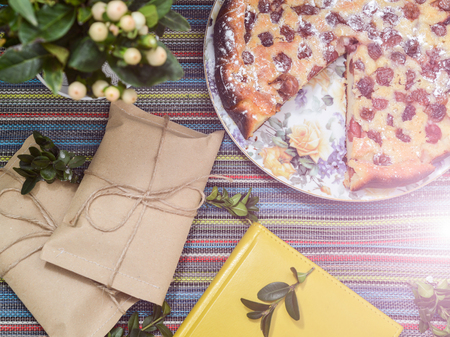 notepad, paper envelope and piece of pie on the colorful tablecloth. sunlightの写真素材