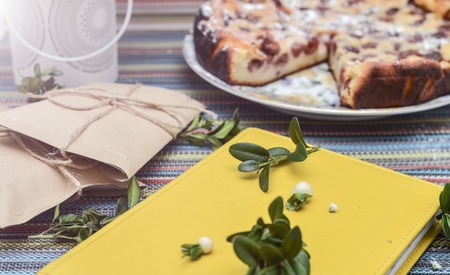 notepad, paper envelope and piece of pie on the colorful tablecloth. sunlightの写真素材