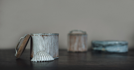 conch and the small boxes painted white on the old brown wooden tableの写真素材