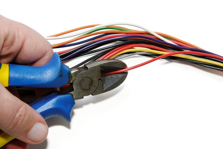 Cutting red cable with nippers isolated on white