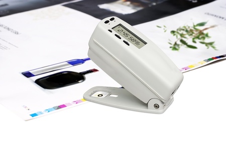 Measuring color density with densitometer on offset printed sheetの写真素材