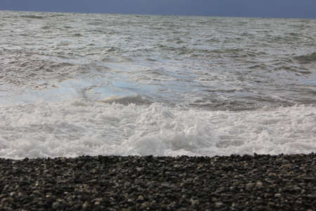 Sea stones on the shoreline in the waves of the sea
