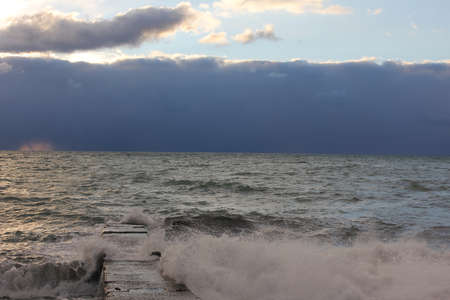 Sea wawes washed dock evening. Sunset on the Sea
