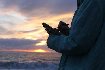 Drawing in a notebook on the waterfront.の写真素材