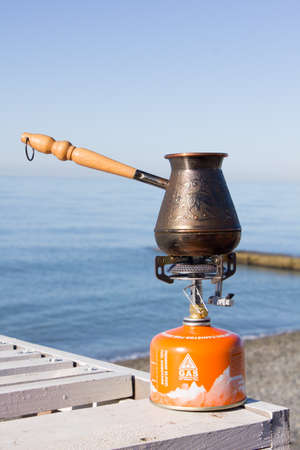 Turk with coffee on a gas burner on the seafrontの写真素材