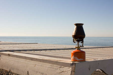 Turk with coffee on a gas burner on the seafrontの写真素材