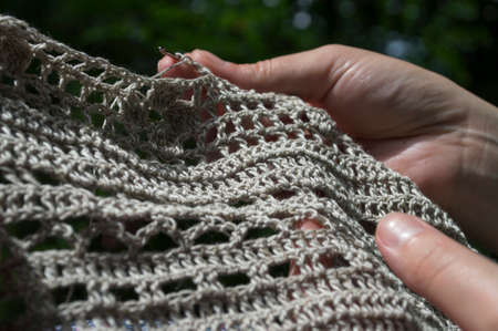 openwork crochet from natural fibers in the wooden backgroundの写真素材