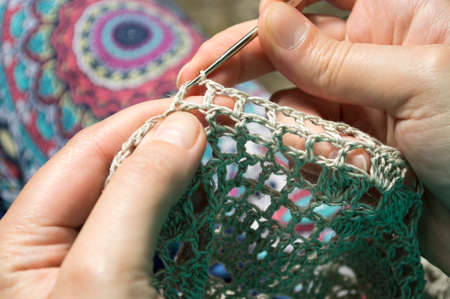 openwork crochet from natural fibers in the wooden backgroundの写真素材