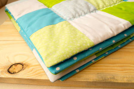 stitched stuffed blanket for babies on a wood background