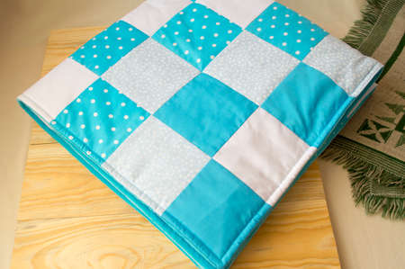 stitched stuffed blanket for babies on a wood background