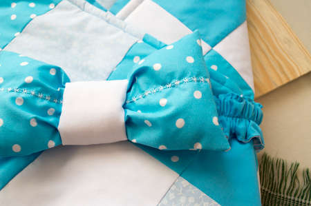 stitched stuffed blanket for babies on a wood background