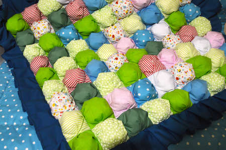 stitched stuffed blanket for babies on a wood background