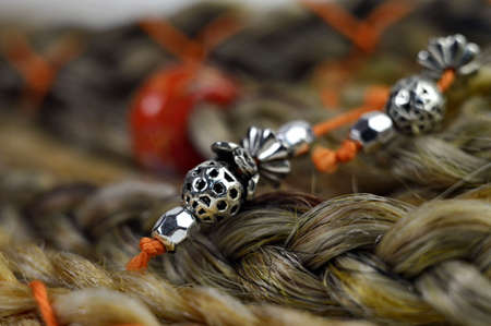 Glass orange bead in braids in hair