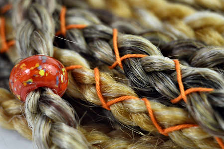 Glass orange bead in braids in hair