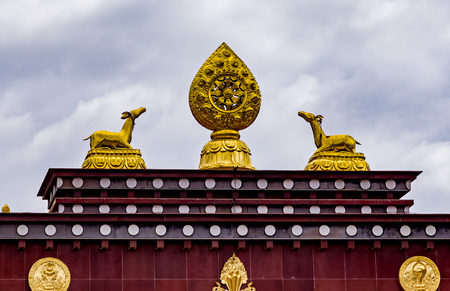 Rooftop statues of two golden deer and Dharma wheel in Songzanlin Tibetan Buddhist Monastery, Zhongdian, Yunnan - China.の写真素材