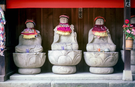 Row of Jizo monk statues with bib and hat - Japan. Jizo is a guardian of aborted children and kids who die prematurely.のeditorial素材