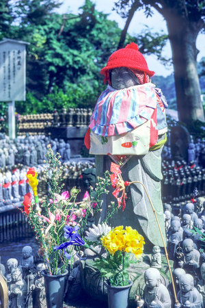Jizo monk statue with bib and hat - Japan. Jizo is a guardian of aborted children and kids who die prematurelyのeditorial素材
