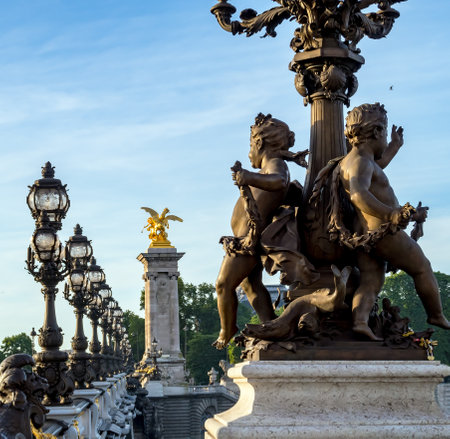 View of Pont Alexandre lll bridge. Close-up on a statue of childrens called Ronde d'Amours with lamps in background - Paris, France.のeditorial素材