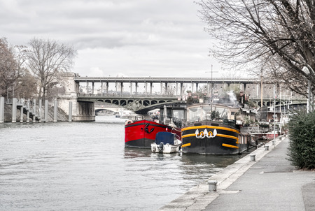 Houseboats moored on the Seine with Pont Bir-Hakeim in background in winter - Paris, Franceの写真素材