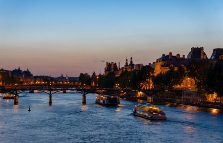 Nightfall over Seine river and Pont des arts with palais royal and musee d'orsay in background - Paris, Franceの写真素材