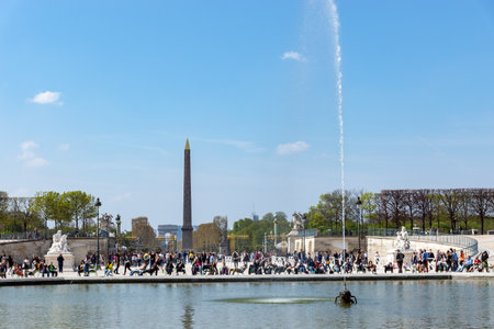 Paris, France - March 31, 2019: People enjoying sunshine in the Jardin des Tuileries in early spring with the Obelisk of Place de la Concorde and the Arc de Triomphe in backgroundのeditorial素材