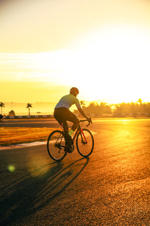 Cyclist riding bicycle on road at sunset. Sport and healthy lifestyle conceptの写真素材