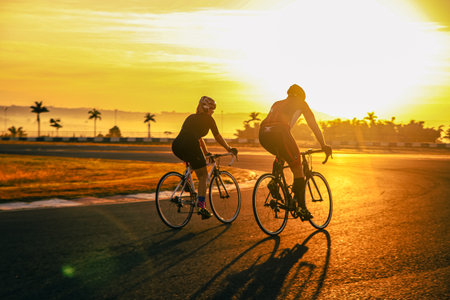 Cyclists riding bicycles at sunset in Los Angeles, California, USAの写真素材