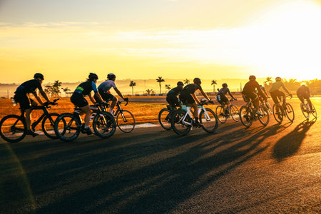 Group of cyclists riding on the road at sunset. Sport and healthy lifestyle concept.の写真素材